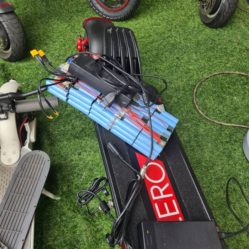 Electric scooter with visible battery pack on a grassy surface