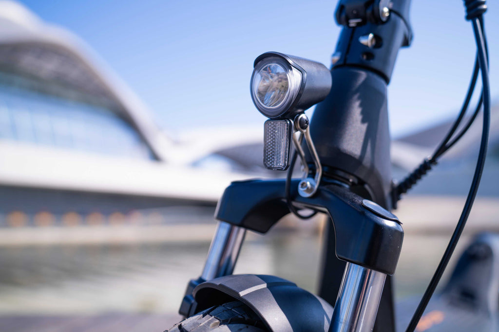 Close-up of a bicycle handlebar with a light against a blurred background