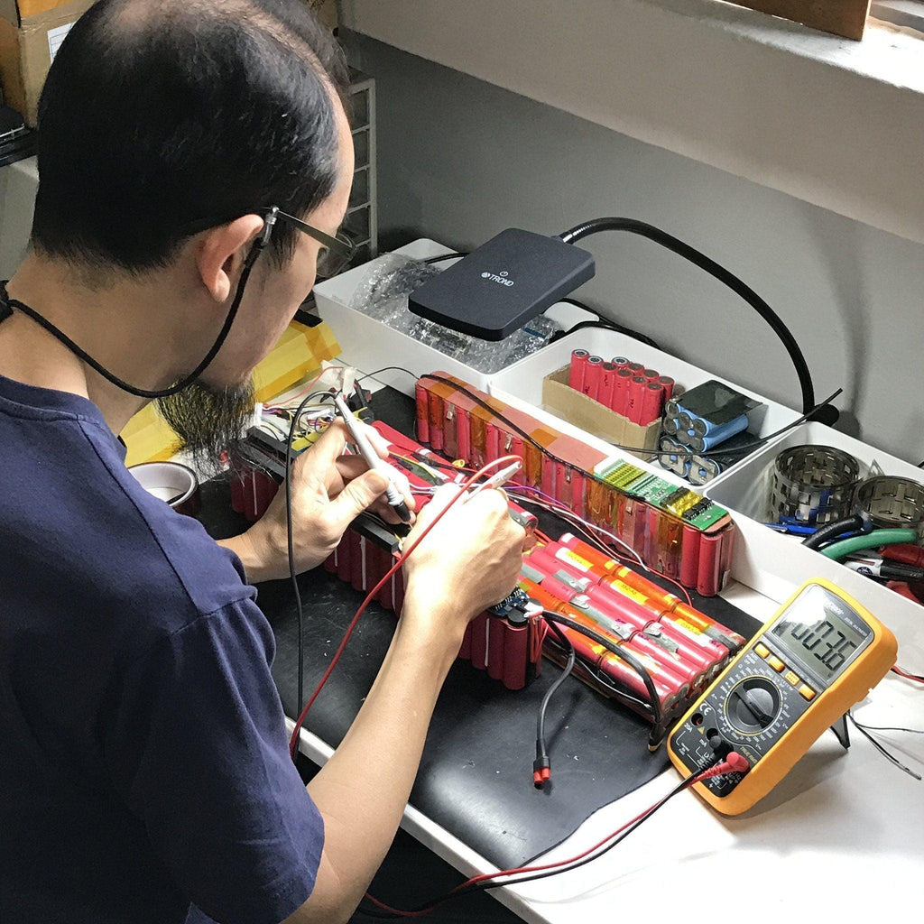 Technician repairing an electric scooter battery at Revolt repair shop in Petaling Jaya 